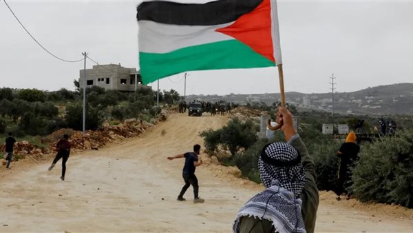 فلسطيني يحمل العلم
